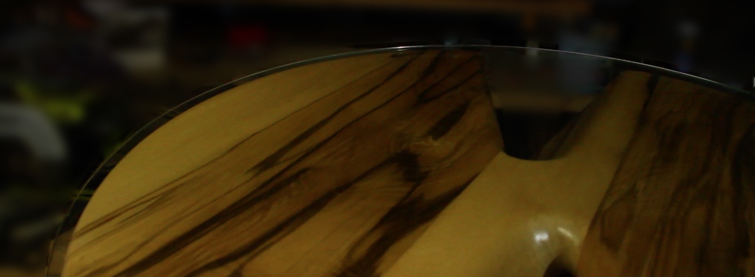 Occasional tables curved in a helix and made from laminated black heart sassafras with a gleaming glass top (view from above).